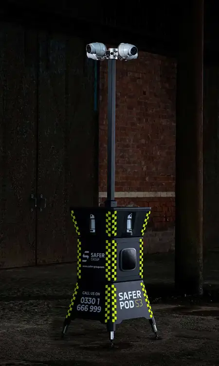 A Safer Pod S3 security unit stands in a dimly lit, industrial space against a brick wall.