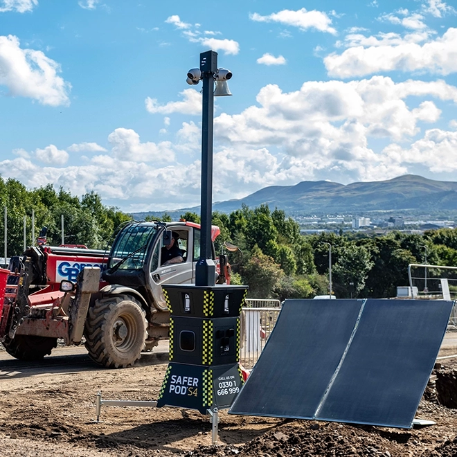 Safer POD S4 with a solar panel on a construction site. A tractor drives by in the background.