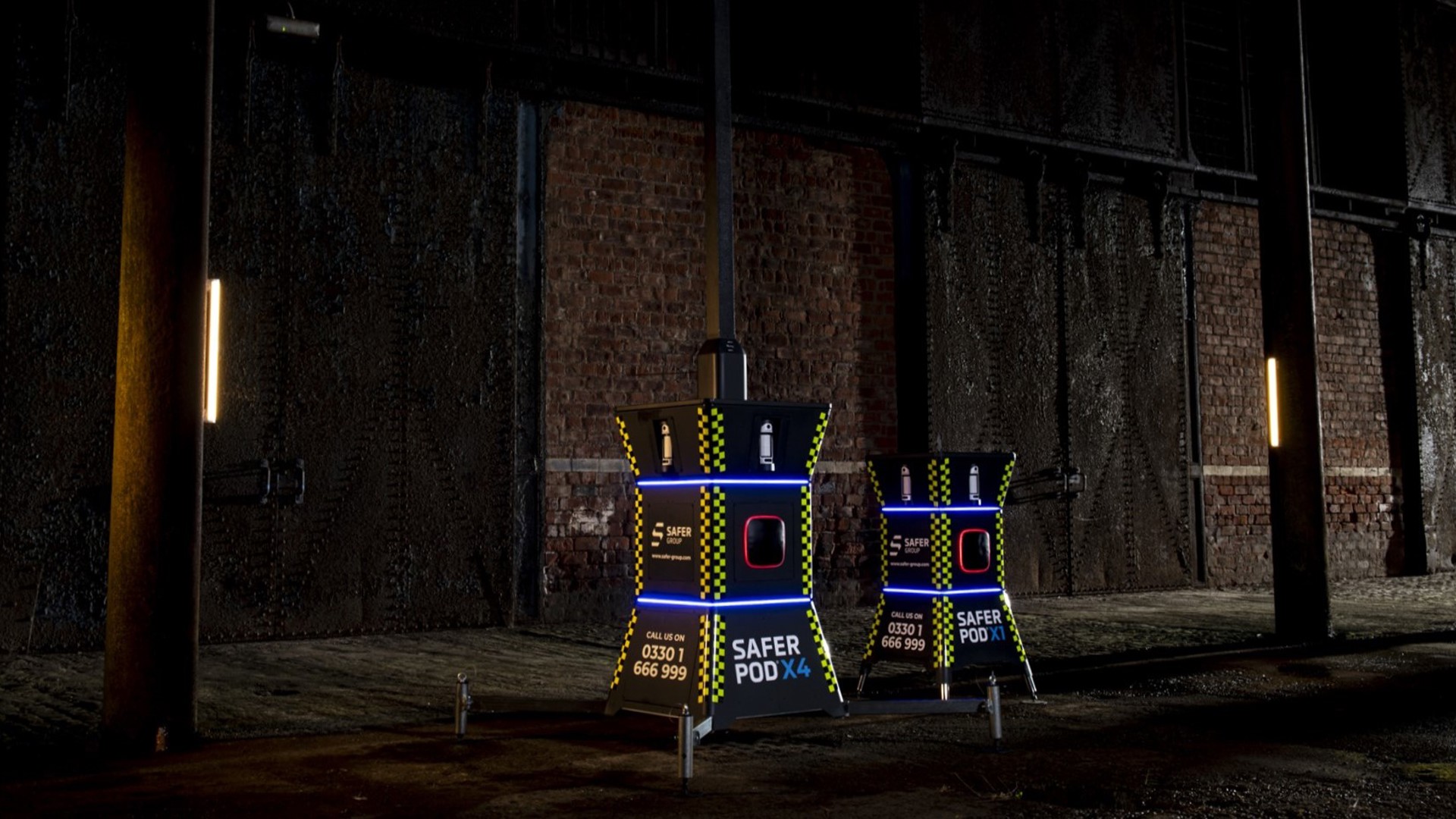 Safer POD X1 and X4 devices stand in a dimly lit industrial space, illuminated with blue LEDs.