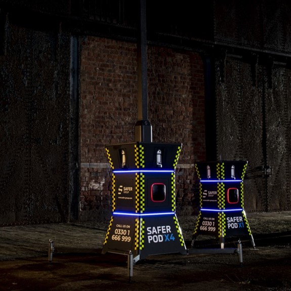 Safer POD X1 and X4 devices stand in a dimly lit industrial space, illuminated with blue LEDs.