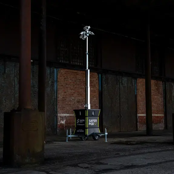 A Safer Pod S7 stands on a concrete floor beneath an industrial structure with brick walls.
