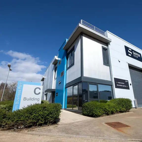 Modern business building with a blue accent, clear signage for "Building C," and a sunny sky in the background.