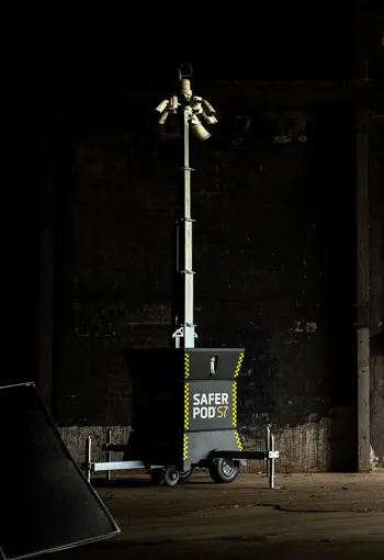 A Safer POD S7 security tower with multiple cameras, set against a dark industrial background.