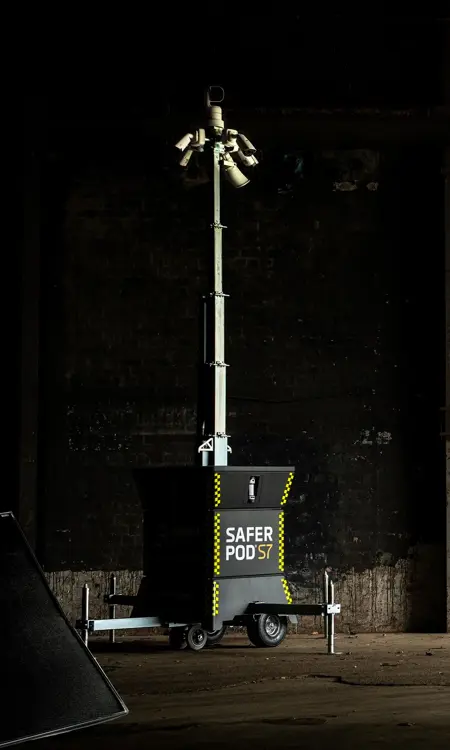 A Safer POD S7 security tower with multiple cameras, set against a dark industrial background.