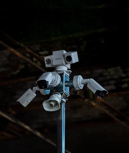 Close up of the top of a CCTV tower with multiple cameras and speakers