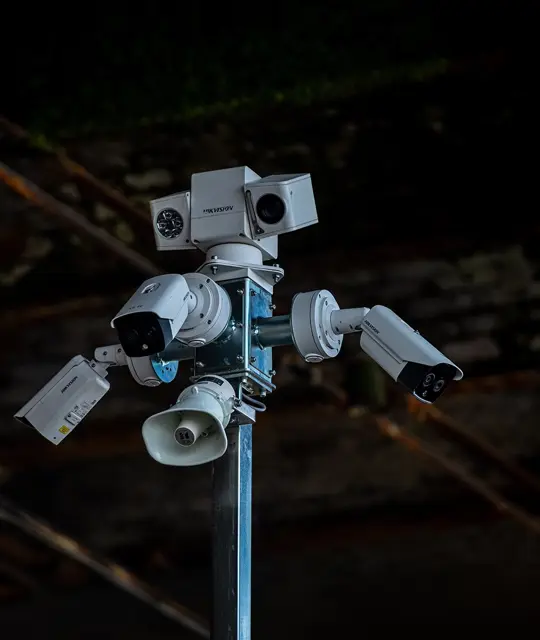 Close up of the top of a CCTV tower with multiple cameras and speakers.